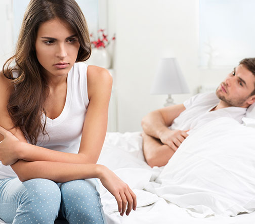 unhappy couple in bed